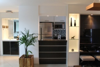 Cozinha americana com passa-pratos integrada com a estante da TV.