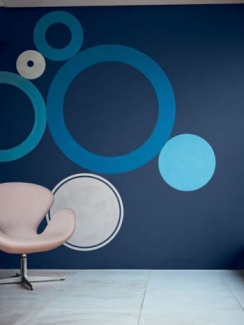 Ambiente gráfico com círculos azuis transforma a parede em uma obra de arte. Aposte no Azul da Coral, Loyal Blue da Sherwin-Williams.