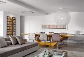 Mesa laqueada de amarelo do designer Guilherme Torres, e De fibra de vidro, o pendente Randon Light, do holandês Bertjan Pot