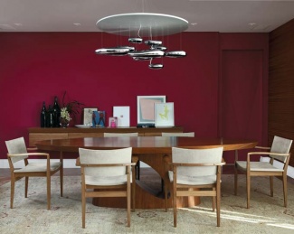 Felipe Alcici é esta sala de jantar. O móvel feito de freijó contrasta com o ambiente vermelho cereja. Com as cadeiras da Etel Interiores e o lustre da La Lampe.