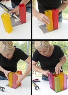 Coloque a cola ao longo de um lado do vaso (lado em que entra em contacto com outro vaso), e em seguida cole-o na placa. Espere secar. Faça o mesmo com todos os outros vasos. Coloque fita para estabilizar e deixe secar.