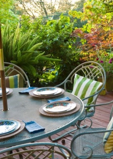 Mesa de ferro retorcido, e cobertura em pérgolas transmite uma ar romântico.