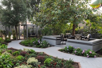 Este ambiente fica um pouco distante da casa - sugestão para quem tem espaço e pode dividi-lo. Mesa central que aproveita a sombra da árvore, cercada por banco de concreto com acento de espuma.