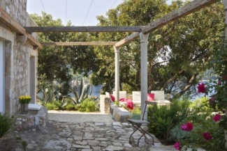 A mesma pedra da parede foi usada para o piso e revestimento do banco de cimento, dando um visual uniforme.