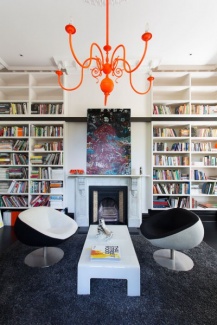 Canto de leitura majestoso, com mobiliário para suporte da coleção de livros dos moradores.