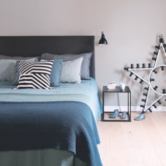 No quarto do casal, azul dos mares com muito gosto. Destaque para a luminária em formato de estrela e os pés azuis para compor a decoração do quarto