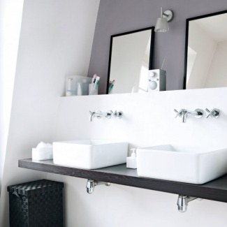 O banheiro branco com bancada em madeira para duas cubas. A parede dos espelhos foi afastada.