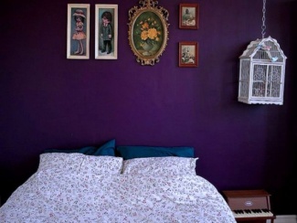 Quarto introspectivo com parede ultra violeta.