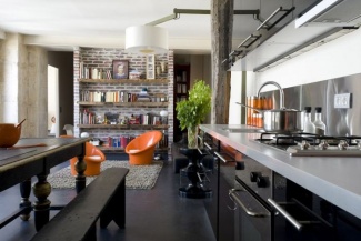 Toque industrial nessa cozinha moderna com armários pretos em aço.