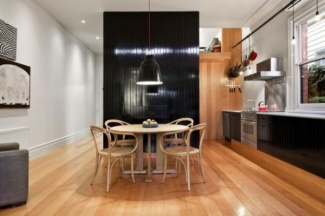 Piso de parte da parede em madeira. Armário com portas em revestimeto de laminado melamínico também usado na parede central da cozinha, Balcão com pedra branca.