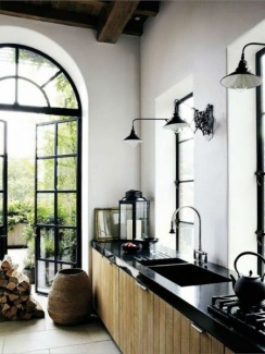 Cozinha industrial com balcão de granito preto e armário de madeira.