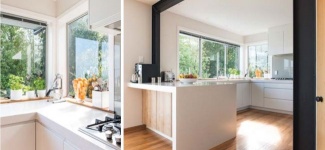 Viga de aço em destaque nesta cozinha. Para contrapor, armários brancos e piso de madeira.