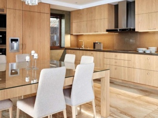 Cozinha com armários e mesa de madeira clara, balcão e parede da pia com o mesmo granito cinza.