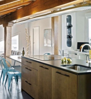 Ilha com cooktop e pia e armários em aço.